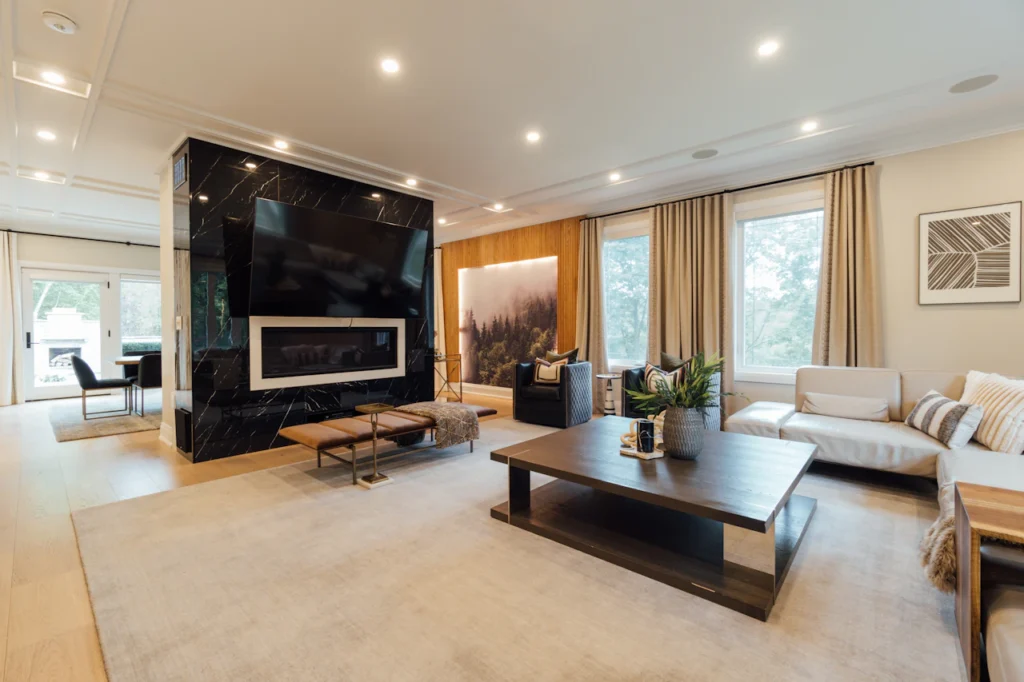 Contemporary living room with layered lighting, large windows and curtains